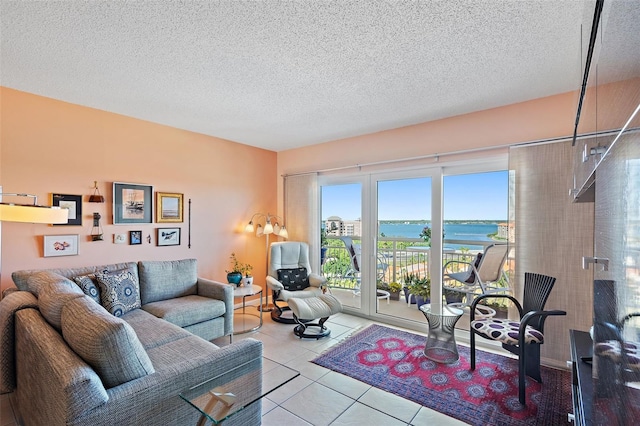 tiled living room featuring a textured ceiling and a water view