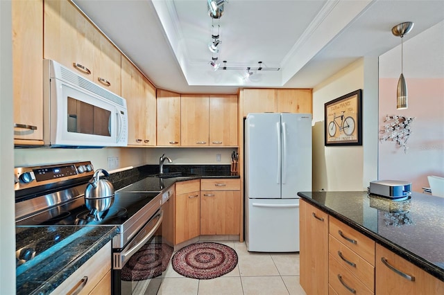 kitchen with dark stone counters, white appliances, light brown cabinetry, and decorative light fixtures