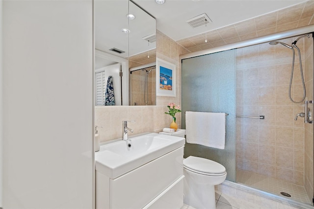 bathroom with vanity, an enclosed shower, tile patterned floors, tile walls, and toilet