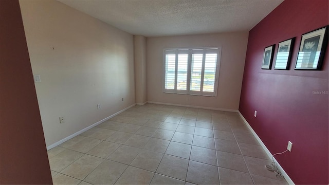 tiled spare room featuring a textured ceiling