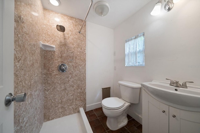 bathroom with tile patterned floors, vanity, toilet, and a tile shower