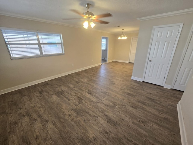 spare room with dark wood-type flooring, ceiling fan with notable chandelier, and crown molding