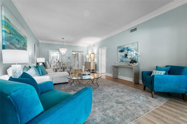 living room featuring hardwood / wood-style flooring, crown molding, and a chandelier