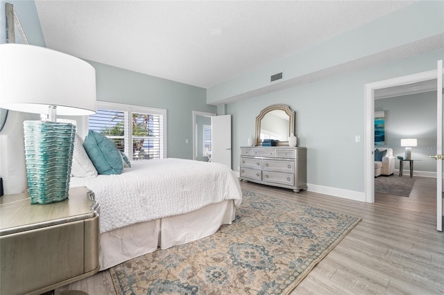 bedroom with a textured ceiling and light wood-type flooring