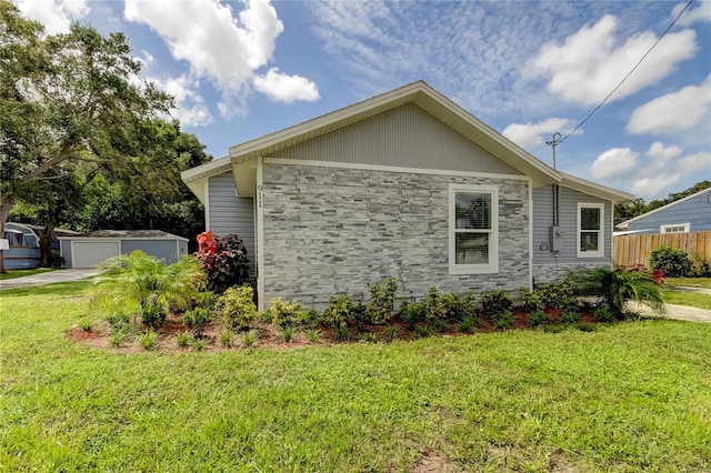 view of side of property featuring an outdoor structure, a garage, and a yard