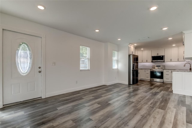 911 8th Ave SW, Largo, FL 33770 - kitchen with stainless steel appliances, dark wood-style floors, a sink, and white cabinetry