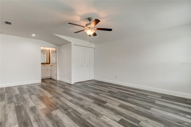 911 8th Ave SW, Largo, FL 33770 - unfurnished bedroom with wood finished floors, a closet, baseboards, lofted ceiling, and visible vents