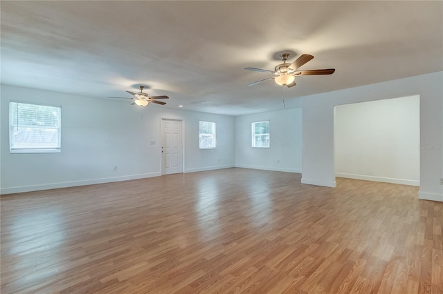 911 8th Ave SW, Largo, FL 33770 - unfurnished living room with light wood-style floors, a ceiling fan, and baseboards
