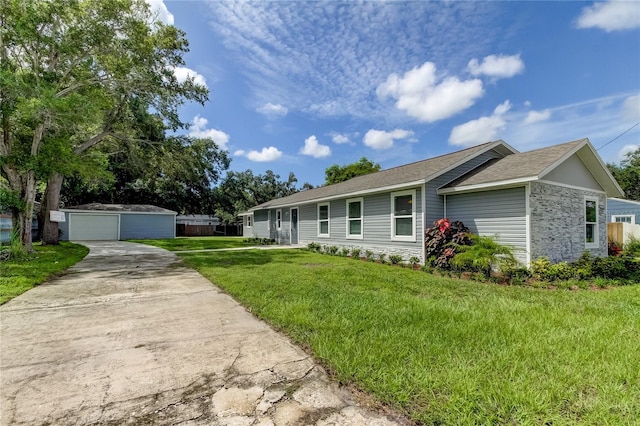 single story home with a garage, a front lawn, and an outbuilding