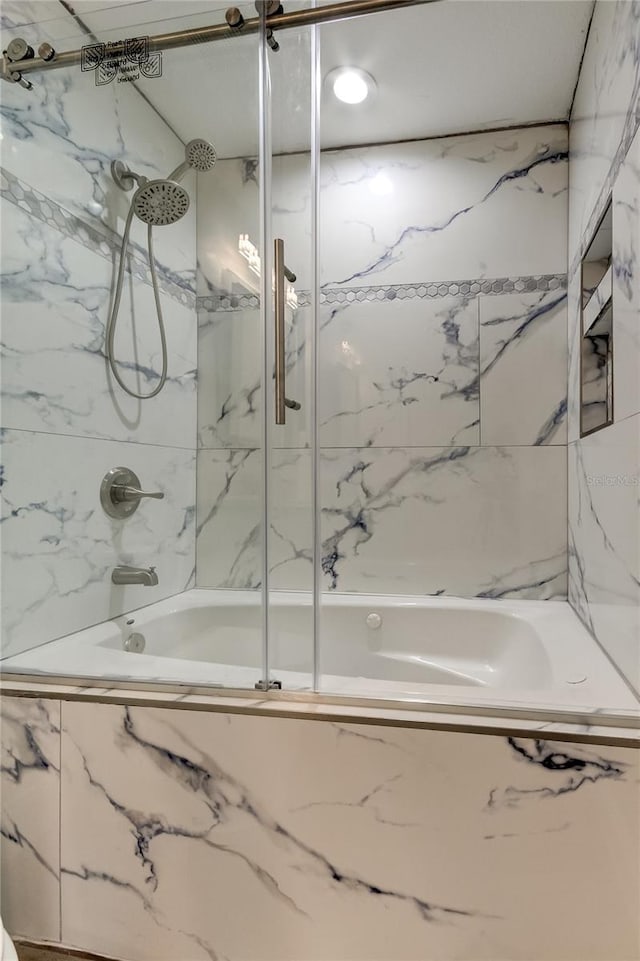 bathroom featuring bath / shower combo with glass door