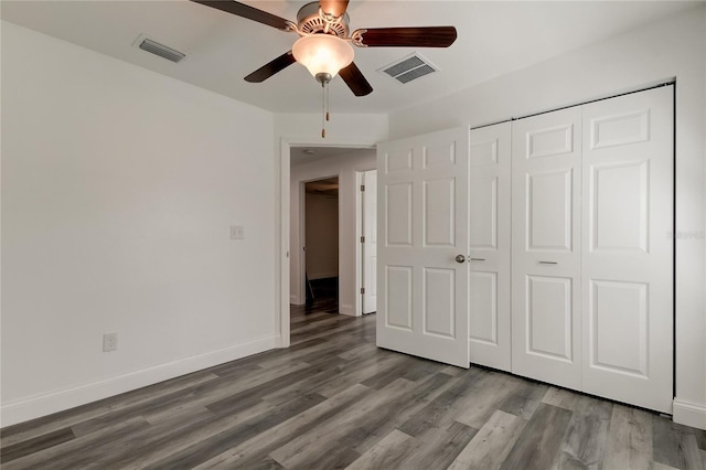 unfurnished bedroom featuring hardwood / wood-style flooring, ceiling fan, and a closet