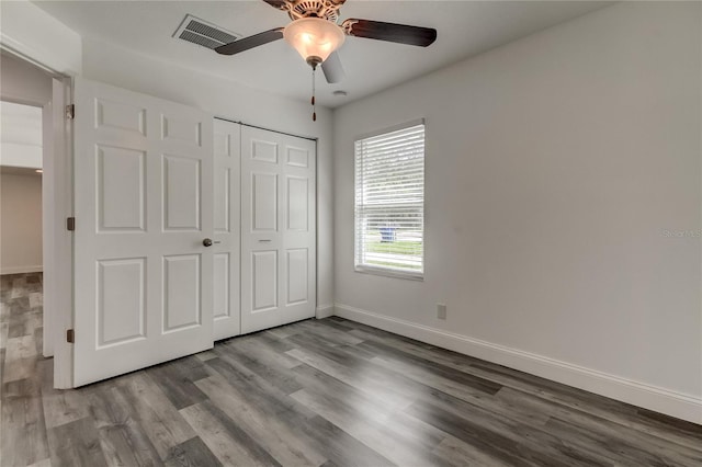 911 8th Ave SW, Largo, FL 33770 - unfurnished bedroom featuring wood finished floors, visible vents, a ceiling fan, a closet, and baseboards