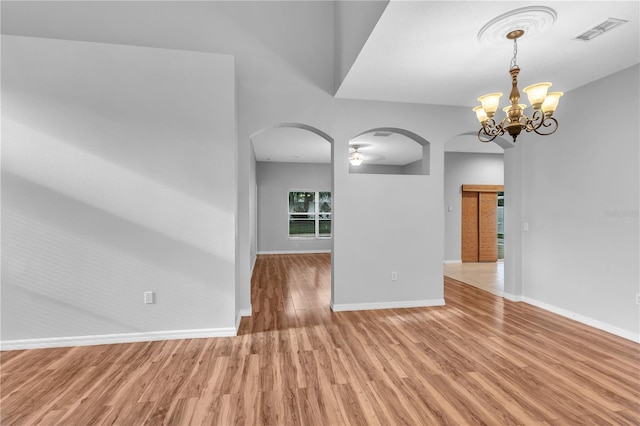 empty room with hardwood / wood-style flooring and a chandelier