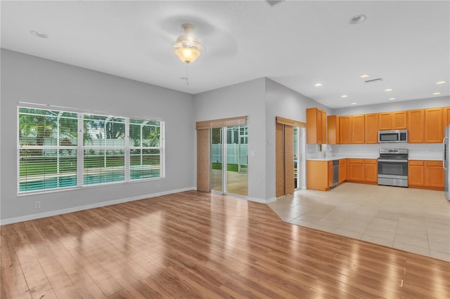 kitchen featuring light hardwood / wood-style flooring, stainless steel appliances, sink, and ceiling fan