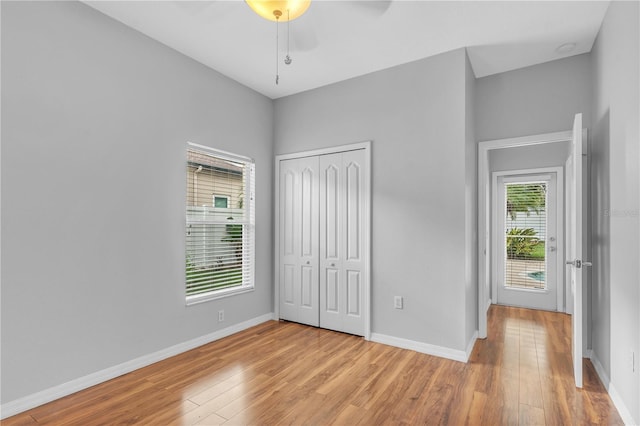 unfurnished bedroom with a closet, ceiling fan, and light hardwood / wood-style floors