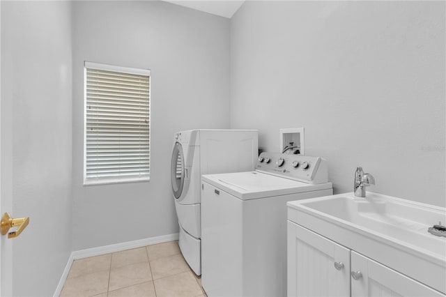 washroom featuring light tile patterned flooring, a wealth of natural light, independent washer and dryer, and sink