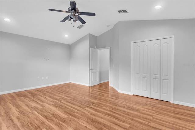 unfurnished bedroom with a closet, ceiling fan, light hardwood / wood-style floors, and vaulted ceiling