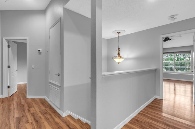 hallway with a textured ceiling and hardwood / wood-style floors