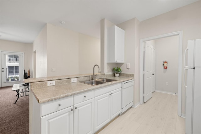 kitchen with white appliances, sink, kitchen peninsula, and white cabinets