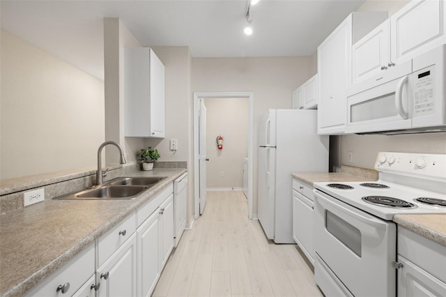 kitchen featuring light wood-type flooring, white appliances, white cabinetry, and sink