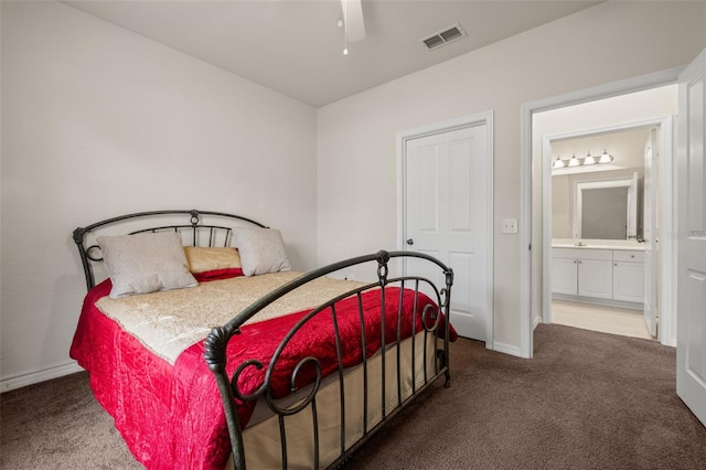 carpeted bedroom with ceiling fan and ensuite bath