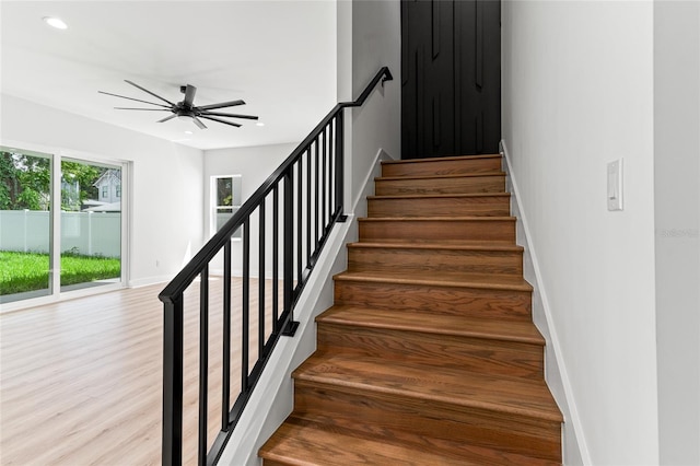 stairs with ceiling fan and hardwood / wood-style floors