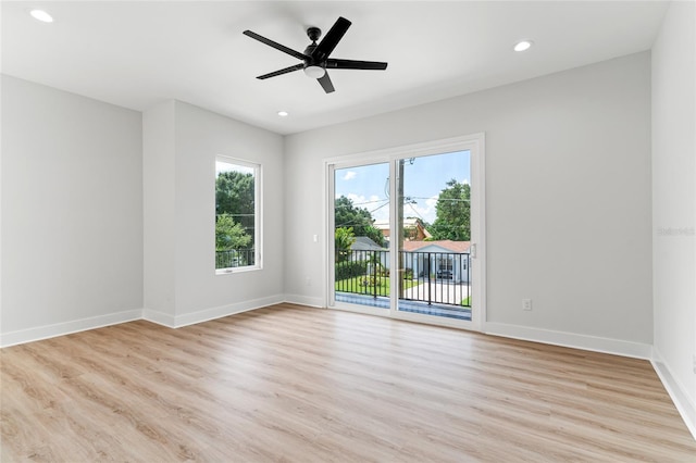 empty room with ceiling fan and light hardwood / wood-style flooring