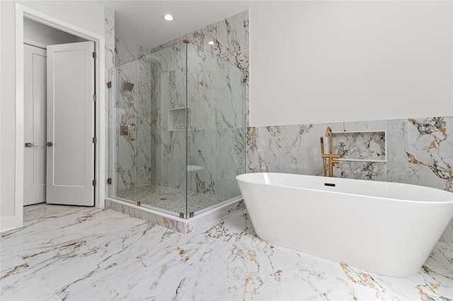 bathroom with tile walls and separate shower and tub