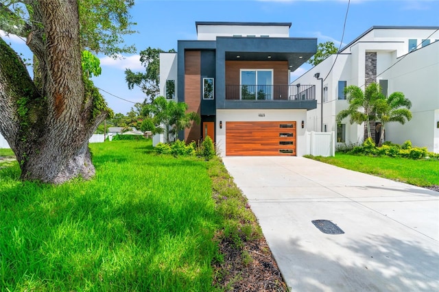 contemporary home featuring a balcony, a front lawn, and a garage