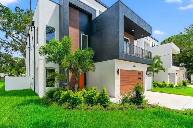 exterior space with a balcony, a front yard, and a garage