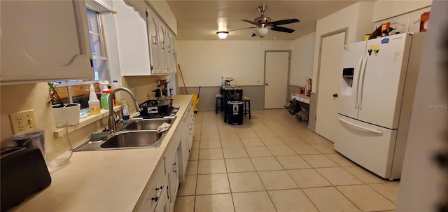 kitchen featuring light tile patterned floors, sink, white cabinetry, white fridge with ice dispenser, and ceiling fan