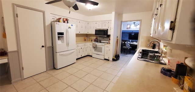 kitchen with white appliances, light tile patterned flooring, sink, ceiling fan, and white cabinets