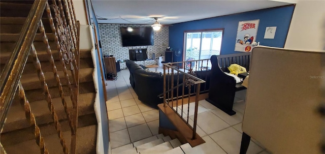 tiled living room with ceiling fan and a brick fireplace