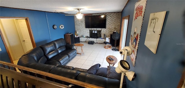 living room with ceiling fan, light tile patterned floors, a fireplace, and a textured ceiling