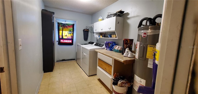 washroom with electric water heater, a textured ceiling, cabinets, and washing machine and dryer