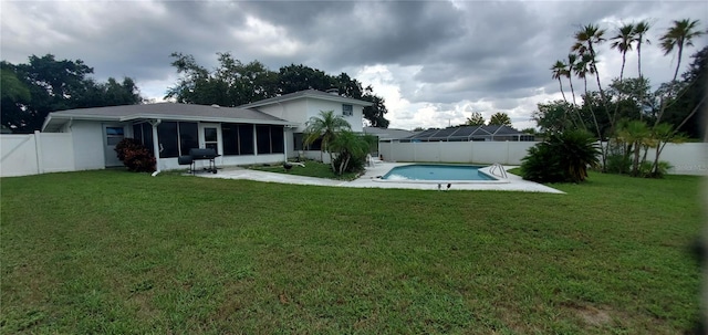 view of yard with a fenced in pool and a sunroom