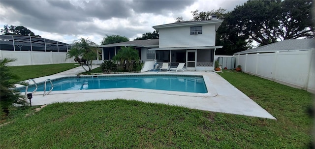 view of swimming pool with a lawn and a sunroom