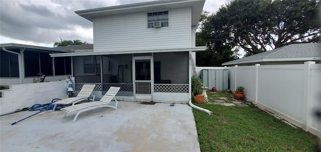 back of property featuring a sunroom, a patio area, a lawn, and cooling unit