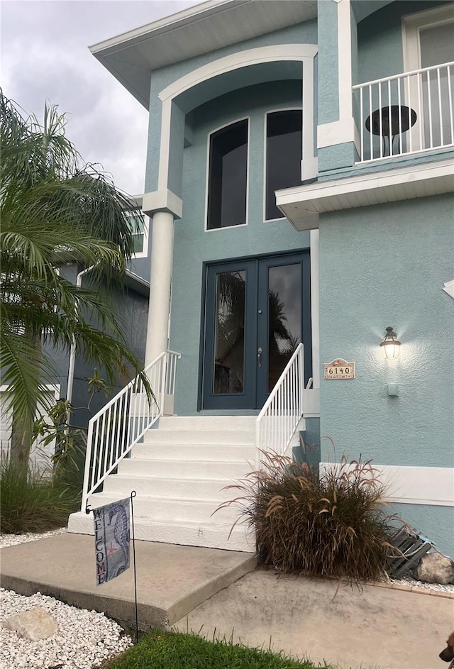 view of exterior entry featuring a balcony