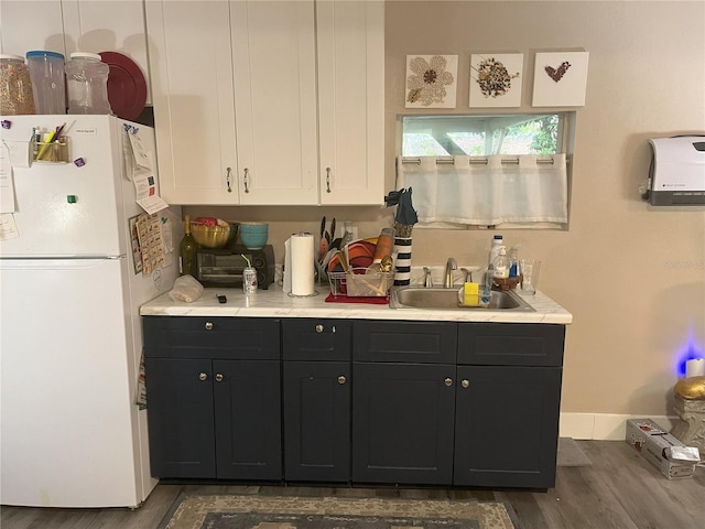 kitchen with white refrigerator, dark hardwood / wood-style flooring, and sink