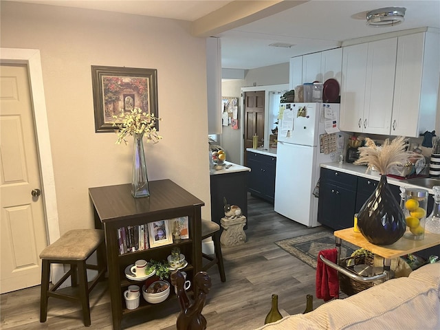 1874 Douglas Ave, Clearwater, FL 33755 - kitchen featuring dark wood-style floors, light countertops, dark cabinetry, and freestanding refrigerator