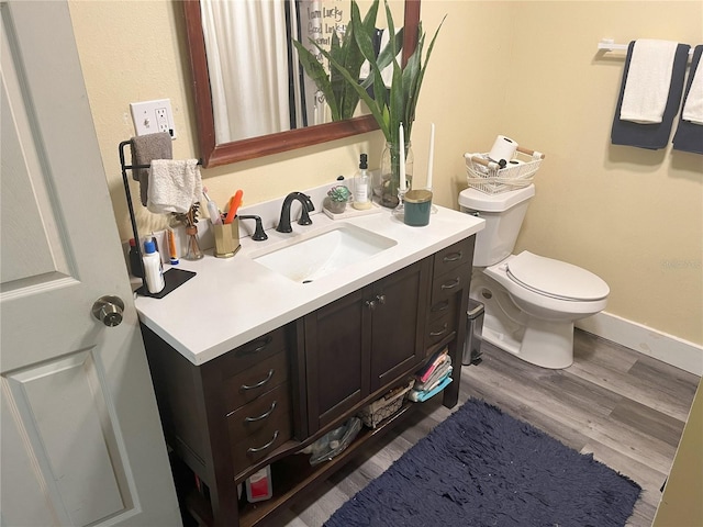 1874 Douglas Ave, Clearwater, FL 33755 - bathroom featuring toilet, vanity, baseboards, and wood finished floors