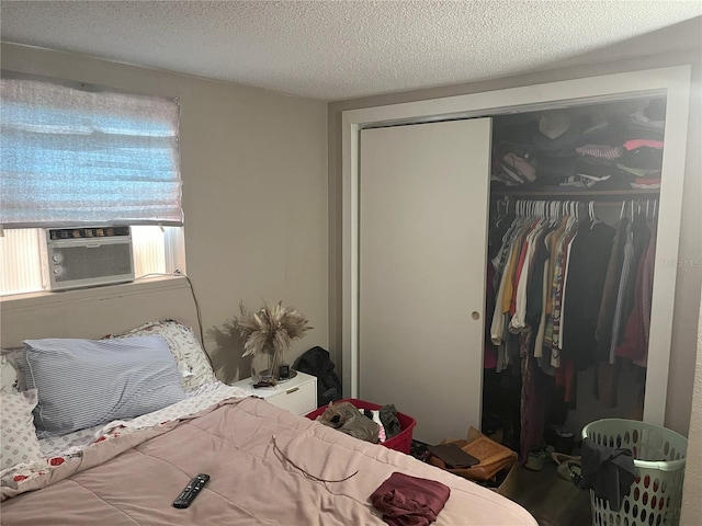 bedroom with cooling unit, a closet, and a textured ceiling