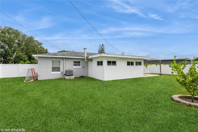 back of property featuring central AC and a yard