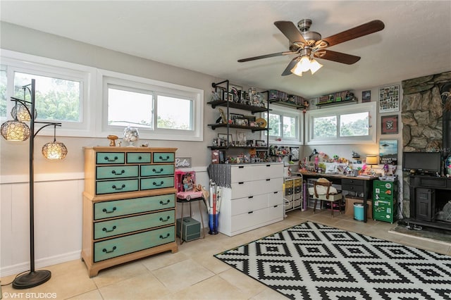 interior space with light tile patterned floors and ceiling fan