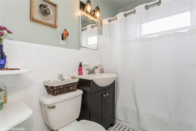 bathroom featuring backsplash, tile patterned floors, toilet, tile walls, and vanity