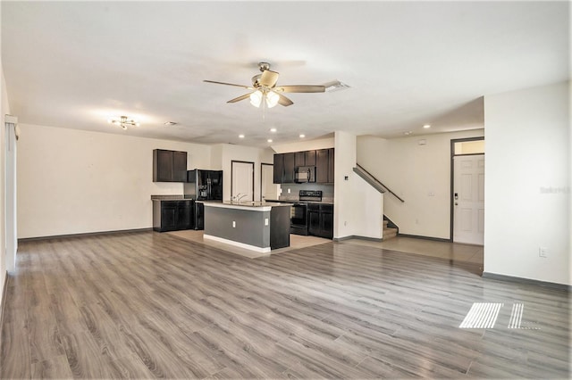 unfurnished living room featuring ceiling fan and light wood-type flooring