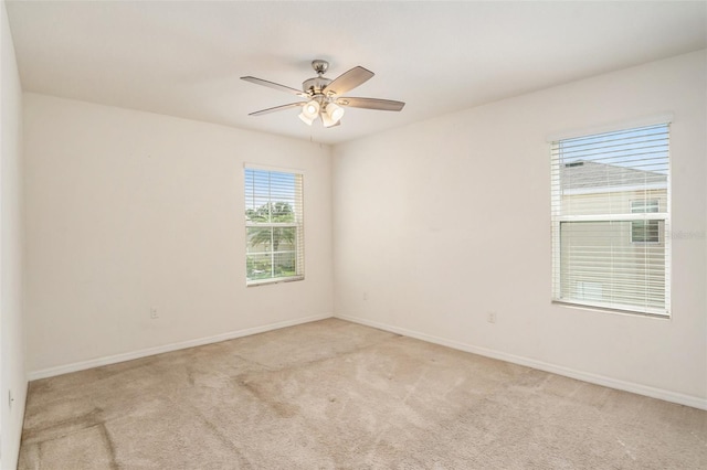 spare room featuring ceiling fan and light colored carpet