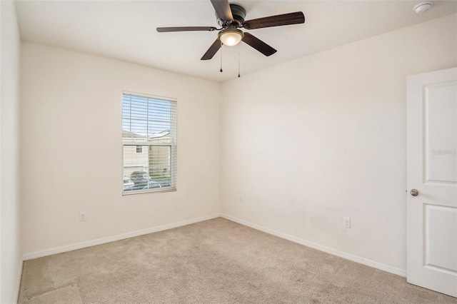 carpeted spare room featuring ceiling fan