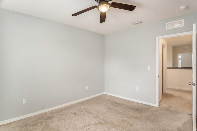 spare room with ceiling fan and light colored carpet